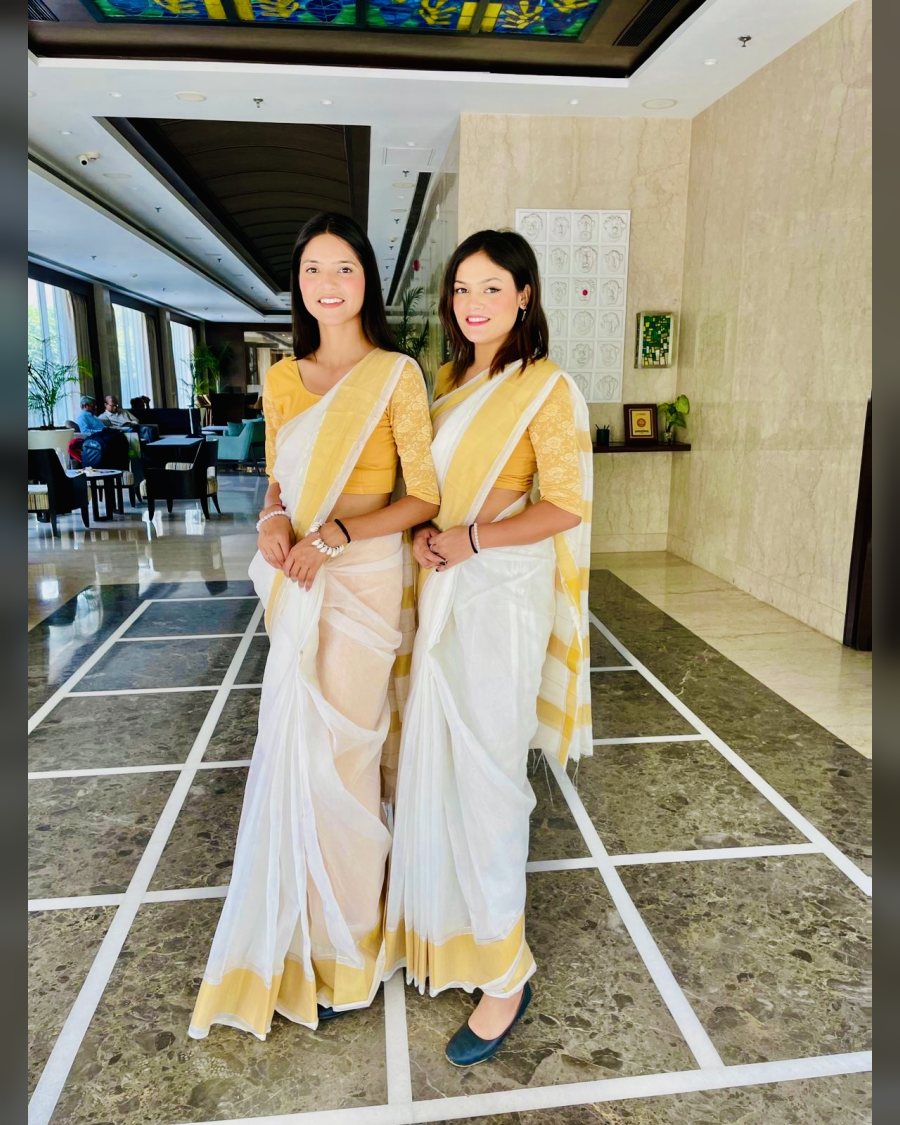 Wedding hostesses in sarees receiving guests in a hotel lobby
