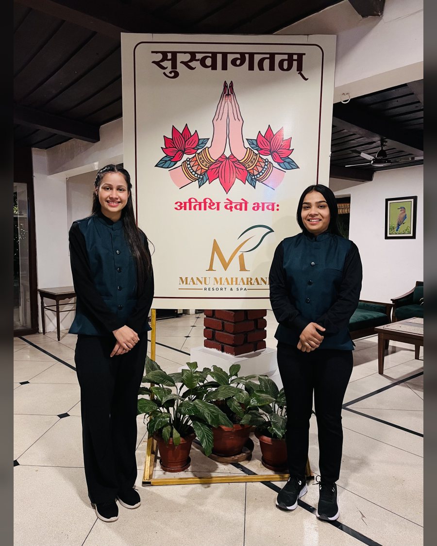 Two hostesses at a resort welcome sign